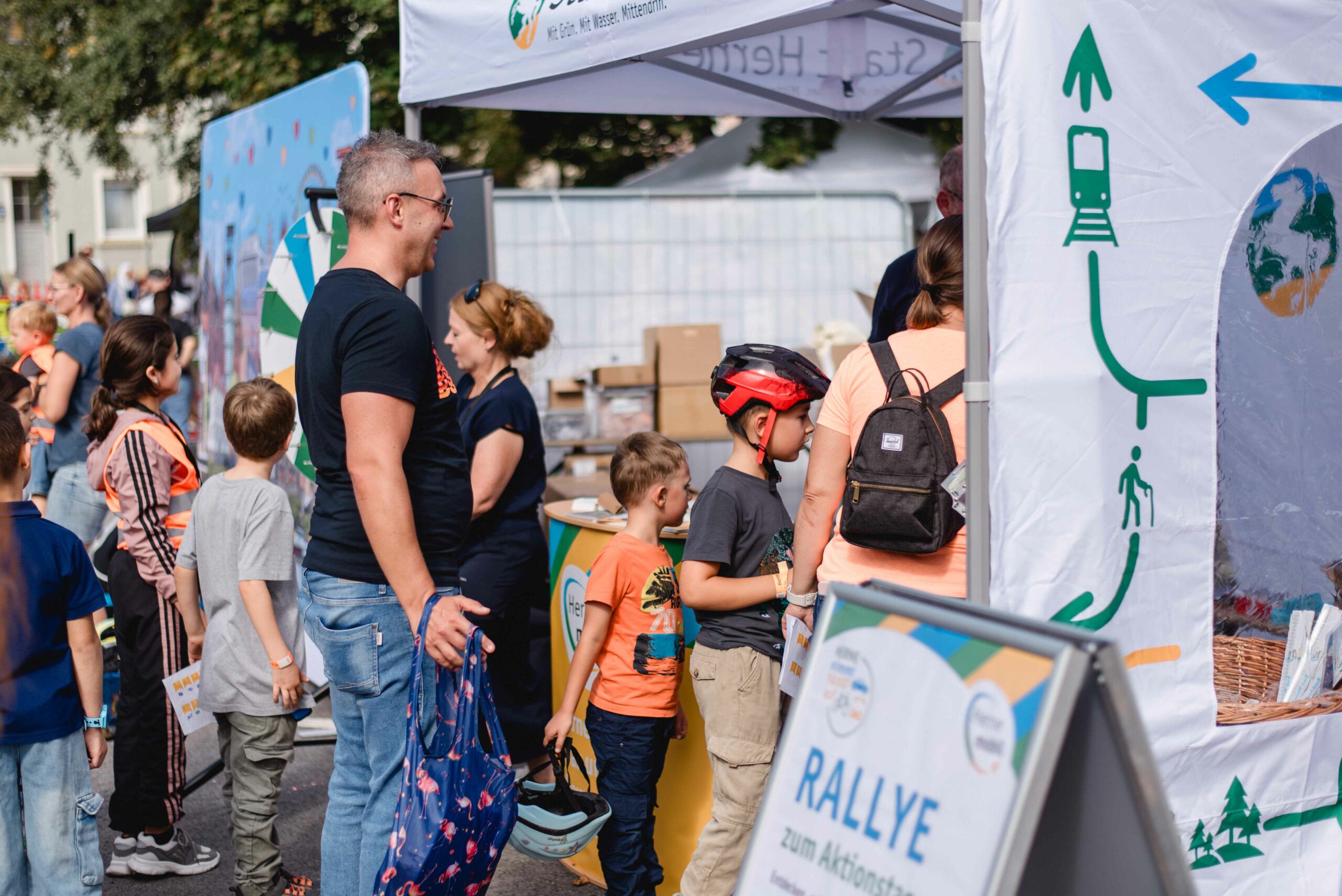 Eltern und Kinder stehen am Aktionsstand von Herne Mobil bei Herne nimmt Fahrt auf