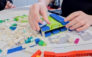 Ein Schüler plant mit Bastelmaterialien das Umfeld der Schule