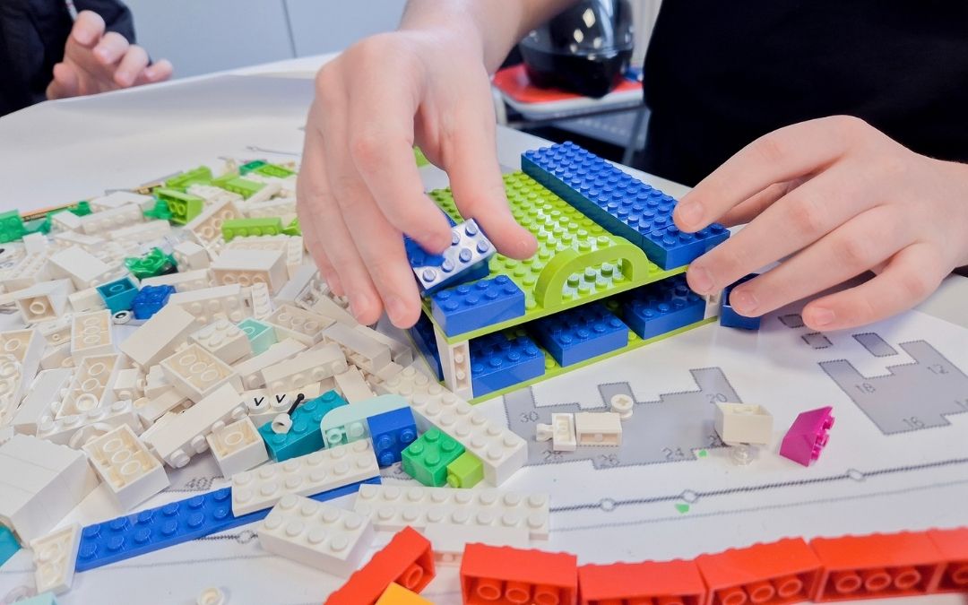 Ein Schüler plant mit Bastelmaterialien das Umfeld der Schule