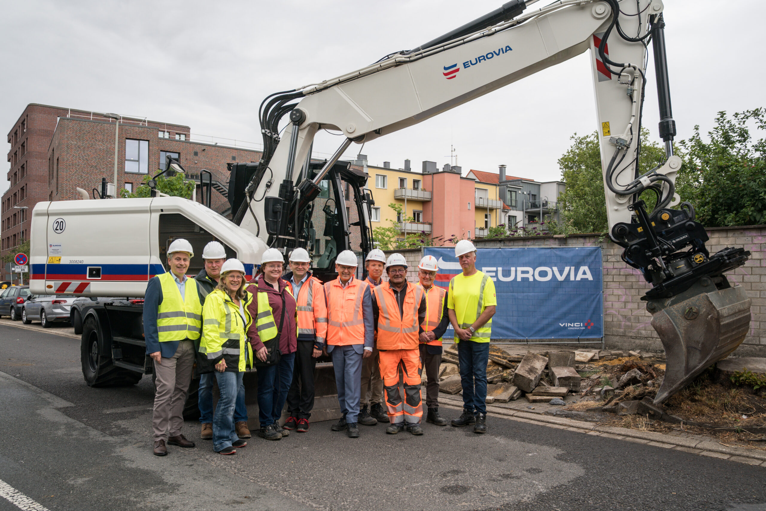 Eine Gruppe vor einem weißem Bagger