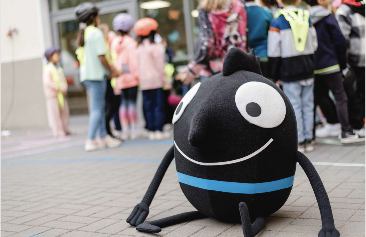 Edgar sitzt auf dem Boden und Kinder sind im Hintergrund